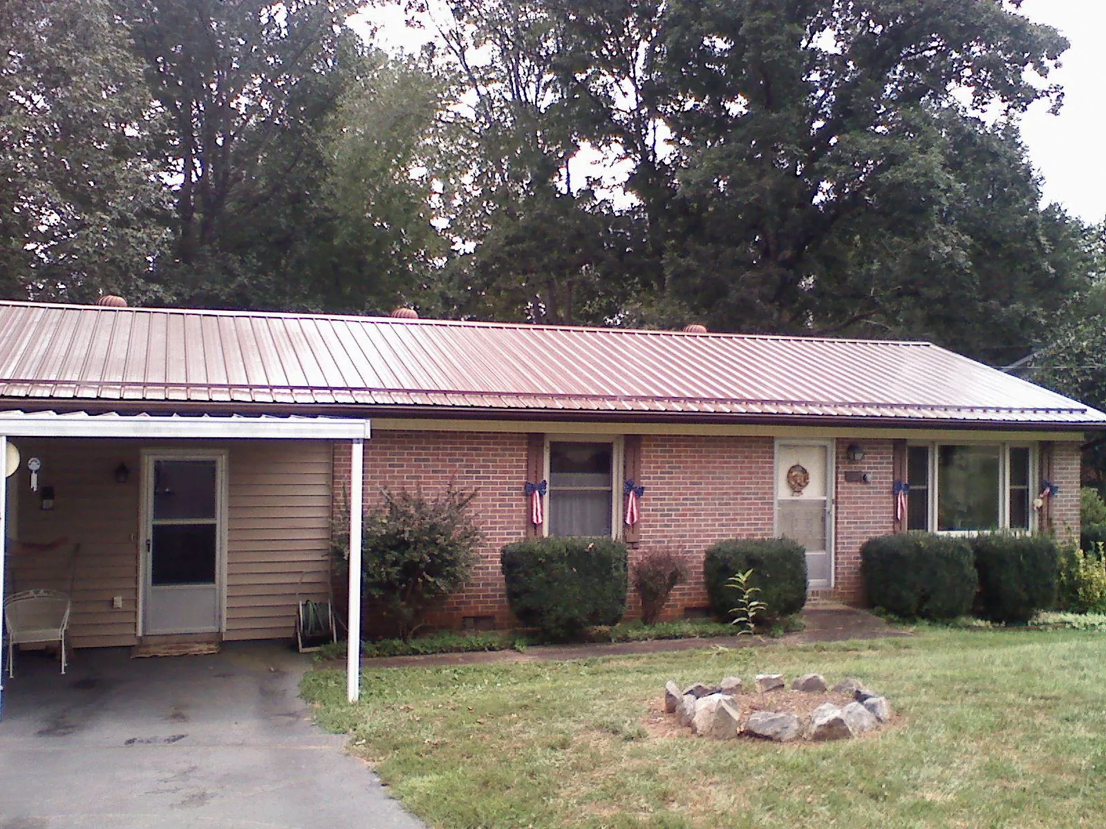 Bronze metal roof and carport on a brick ranch home — Roof Repair work by our crew in Saint Clair